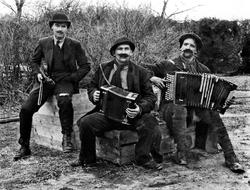 Tre muntre musikanter med fionlin og torader mm. Ukjente per