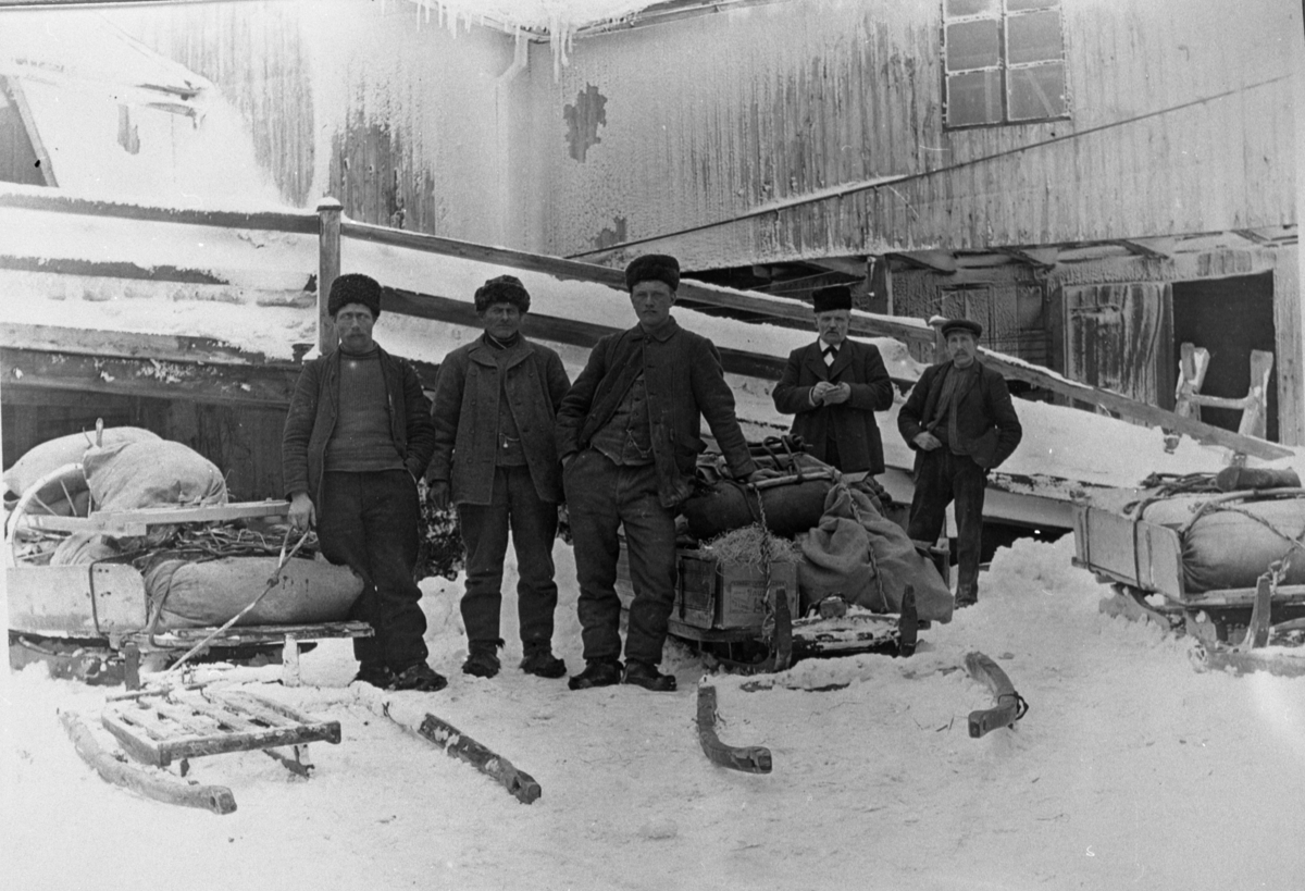 Svenskhandel i Volqvartsgården. Fem mann med sleder og oppakning foran låvebrua i forretningsgården til Peder Holden
