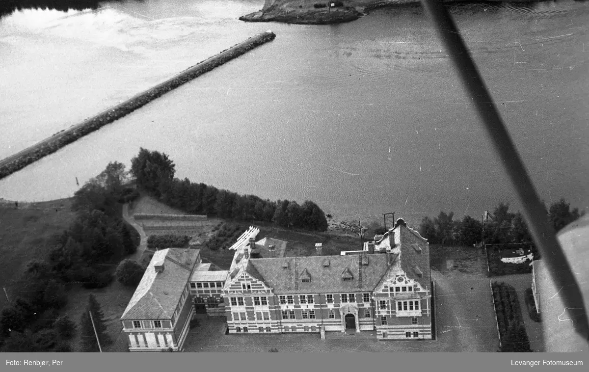 Flyfoto av Levanger, tatt av tenåringen Per Renbjør med sin fars Leica.  Den gmle lærerskolen og Jetèen over sundet.