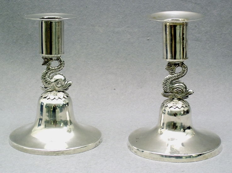 Enl liggare:
"Ljusstakar, 1 par av silver, ciselerade delfiner sammanbinder ljushållare och foten. Höjd 11,3 cm. Stämplar: M.F. (Magnus Fryberg 1817-1830) - tre kronor - Jönköpings stadsstämpel - M3 (1818)"