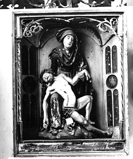 I Västergötlands museums samlingar. 
Inv.nr. 7798

PietÃ , framställning av den sörjande jungfru Maria, sittande med den döde Kristus i sitt knä. Motivet har sin bakgrund i senmedeltidens passionsmystik och uppstod i Rhenområdet i början av1300-talet. Det blev därefter vanligt i både måleri och skulptur. En ensam sörjande Maria kallas mater dolorosa. 
http://www.ne.se/jsp/search/article.jsp?i_art_id=283310