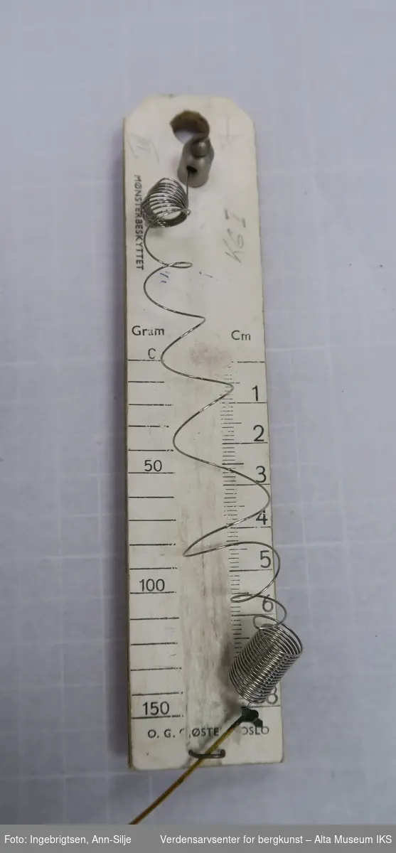 Form: Stålfjær montert på avlang, gradert finérskive
