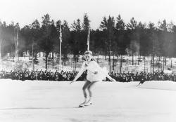 Jente, klær, skøyter (kunstløp), tilskuere.