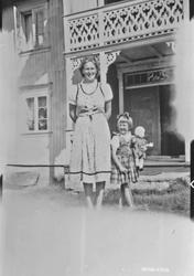 Personer, klær, dokke, bolighus.