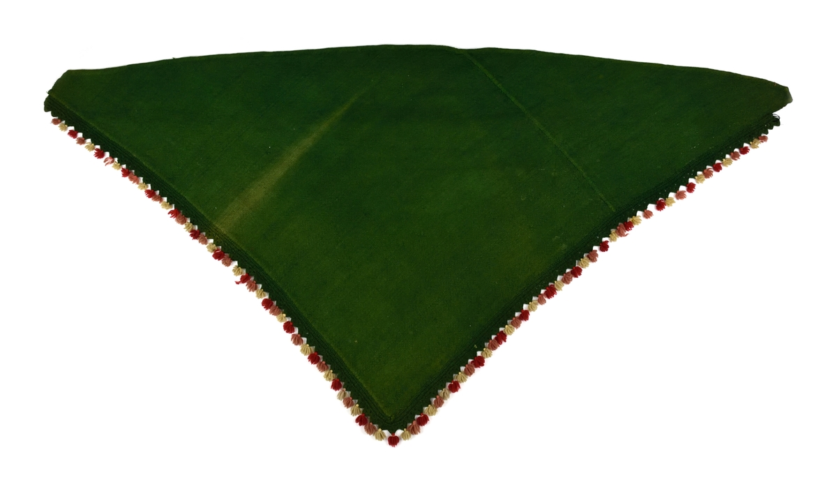 Sidorna med stickade uddar i grönt och små tofsar i rött och vitt. Liknande schal finnes i Järvsödräkten.