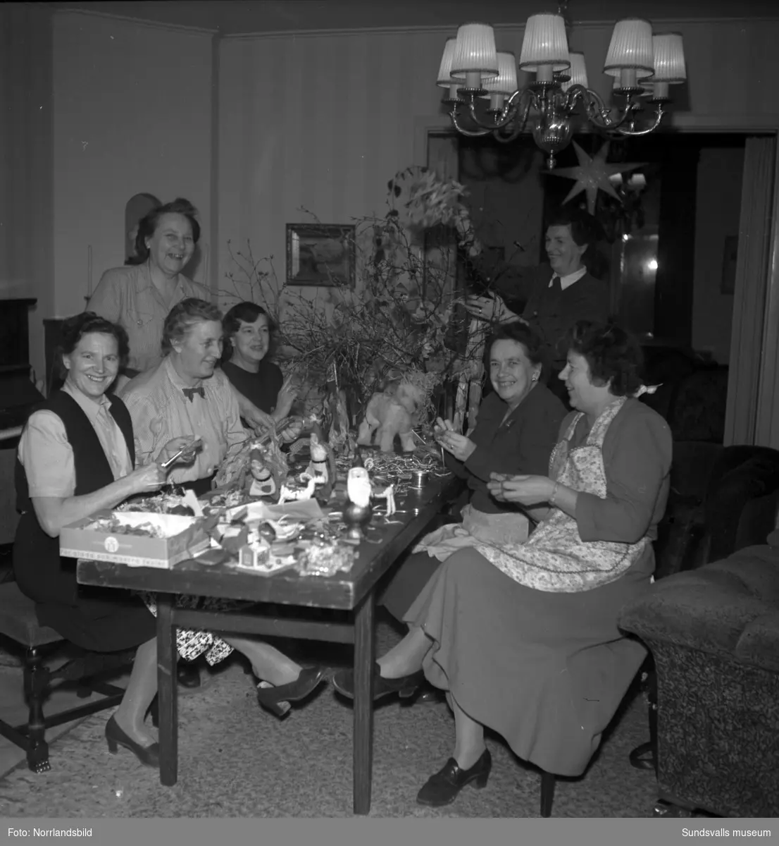 Odd Fellow-mässa inför lucia. Sju damer runt ett bord med julpynt.