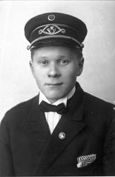 Portrett i halvfigur av poståpner Edvard Ruud iført embetsun