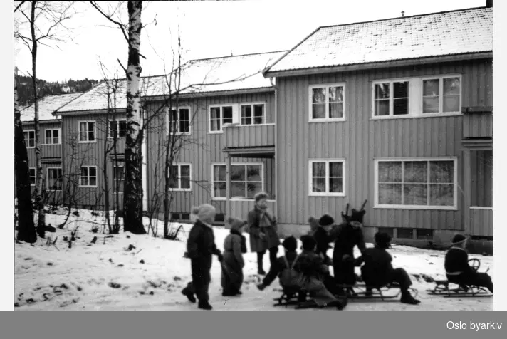 Rekkehus, Holmenhaugen borettslag, søndre. Holmengrenda 13 til 31. Barn med kjelker i forgrunn, snø.