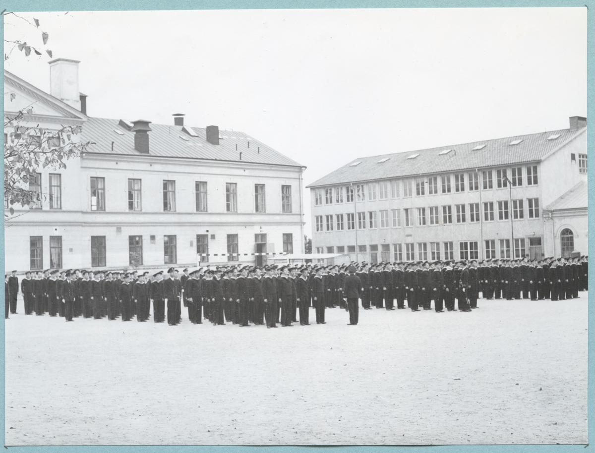 Bilder från Krigsmans erindran den 13/10 1951. Uniformsklädda flottister står uppställda på bataljon Sparres kaserngård. I bakgrunden syns bl.a. matinrättningen tillhörande Sparre.