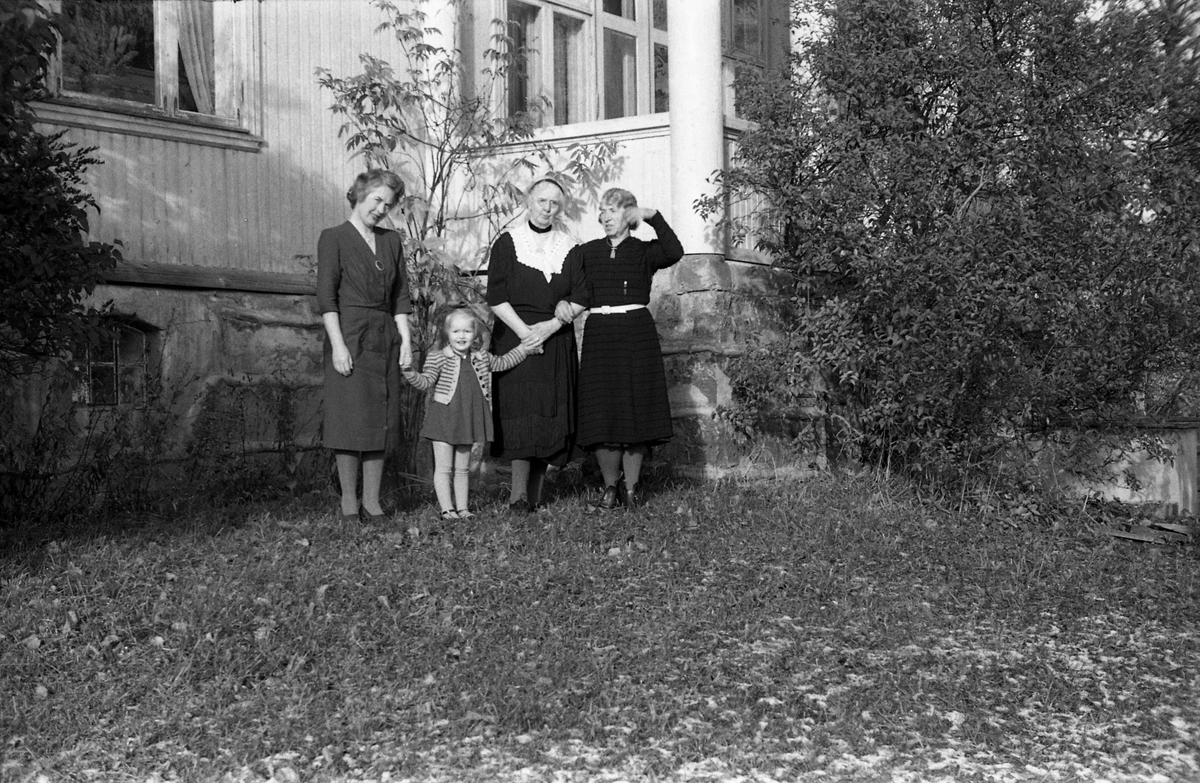 Tre kvinner og en jentunge foran Kvale-Hougens bolig Heggen på Kraby i Østre Toten. Nummer to fra høyre er Ella Eriksen som Kvale-Hougen hadde kjøpt Heggen av, og som fremdeles bodde der. Lengst til høyre trolig fru Kvale-Hougen. Den yngre kvinnen og jentungen er ikke identifisert.