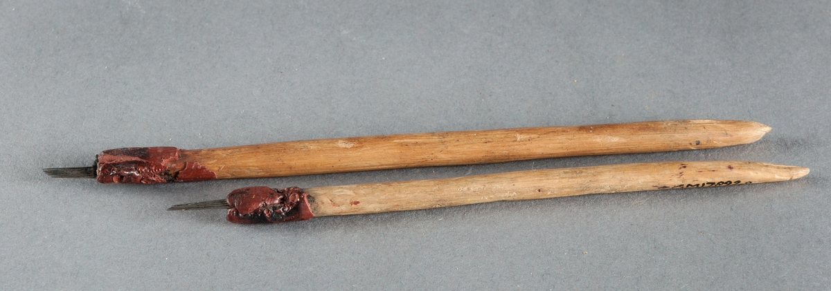 Tatueringsnålar. Nålarna är fästade vid de runda trähandtagen medels rött lack. Användes av givaren sommaren 1917 då han utförde sin verksamhet på inkomna båtar i hamnen. Verksamheten förbjöds sedemera.

Nål A har 5 nålar.
Nål B har 8 nålar.