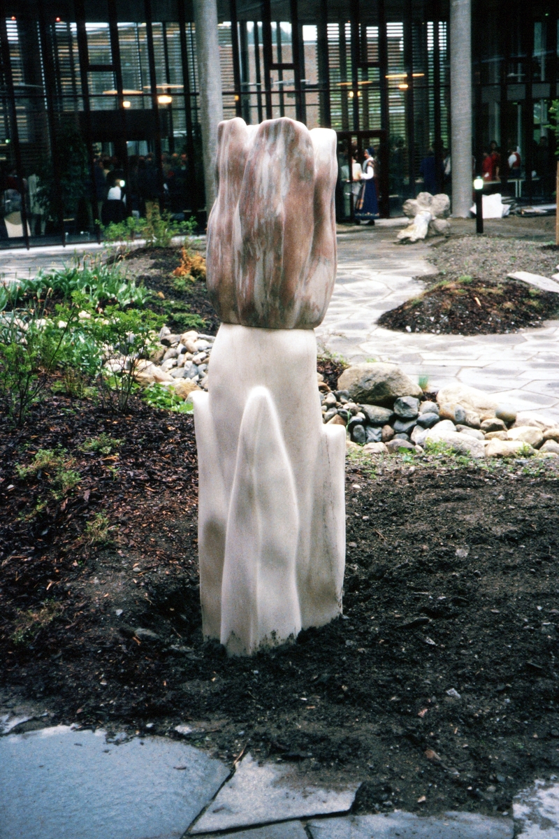 Arbeidet forestiller en tulipan der stilk og blader er laget i hvit marmor og blomst i rosa marmor fra Fauske, og inngår i en utsmykning bestående av et større parkanlegg i byggets atrium. Skulpturen er organiske i sitt uttrykk, struktur og tekstur som skal tydeliggjøre og være endel av parkanleggets frodighet og tilsynelatende tilfeldige planlegging. 
Tre skulpturer, sittebenker, bruddheller og beplanting inngår også i utsmykningen.