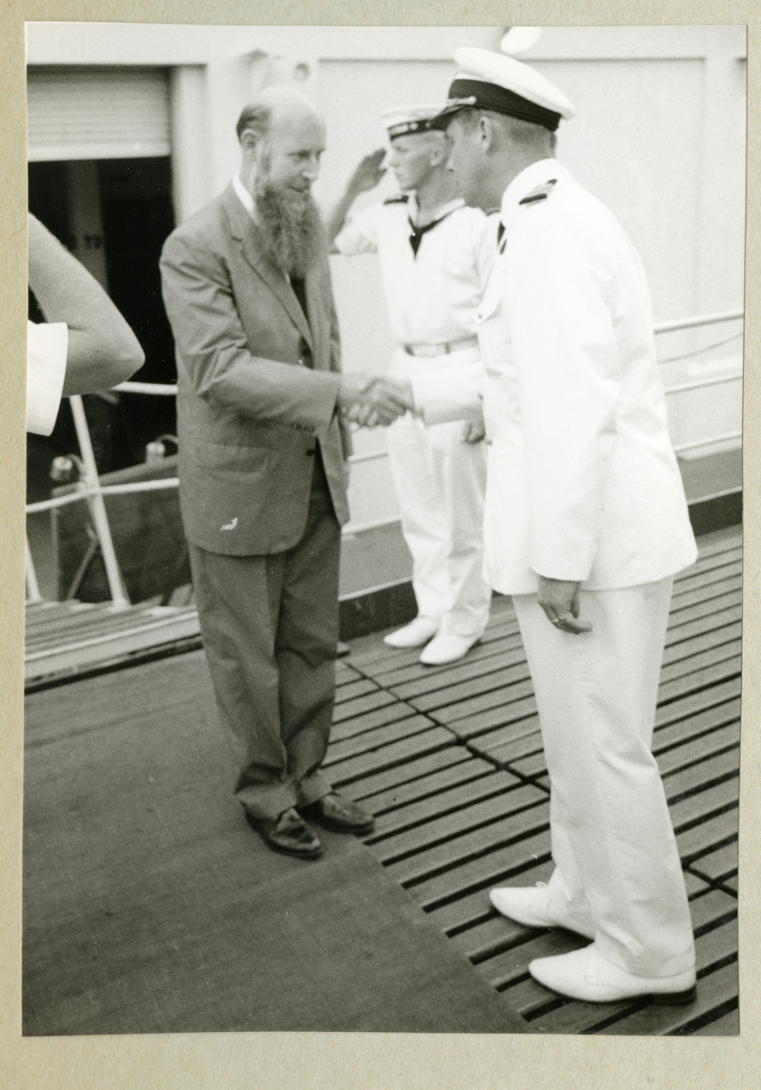Bilden föreställer en besättningsman i vit uniform som tar i hand med Bengt Danielsson, som var deltagare i Thor Heyerdahls Kon-Tiki-expedition 1947. Bilden är tagen under minfartyget Älvsnabbens långresa 1966-1967.