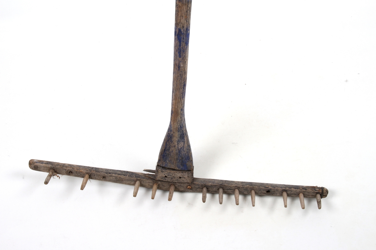 Trerive med rester av blåmaling. Brukt til å rake høy.