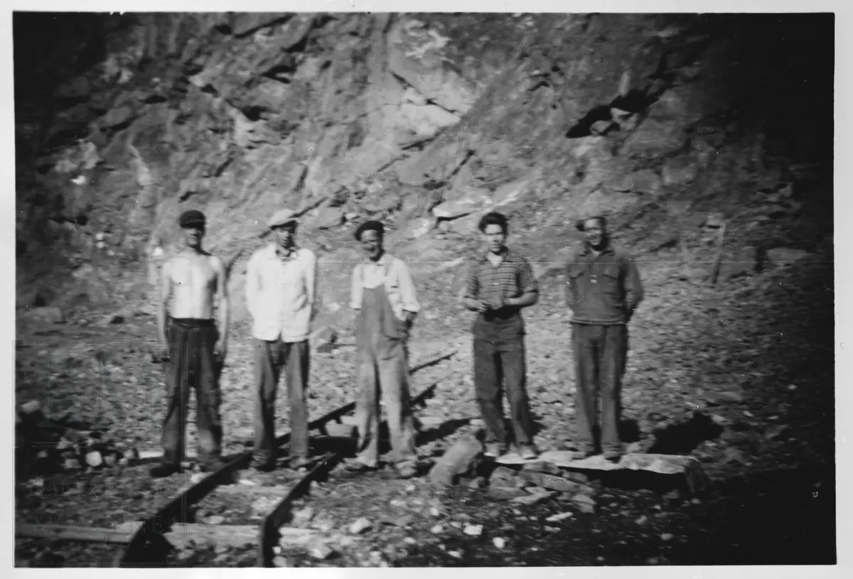 Fem arbeidere står i et kalksteinbrudd.