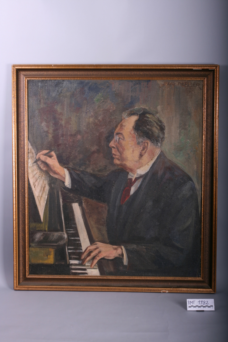 Komponist Eilif Gulbranson sittende ved et klaver. Den ene hånden på tastaturet, den ande med en penn hvor han noterer ned på et noteark.