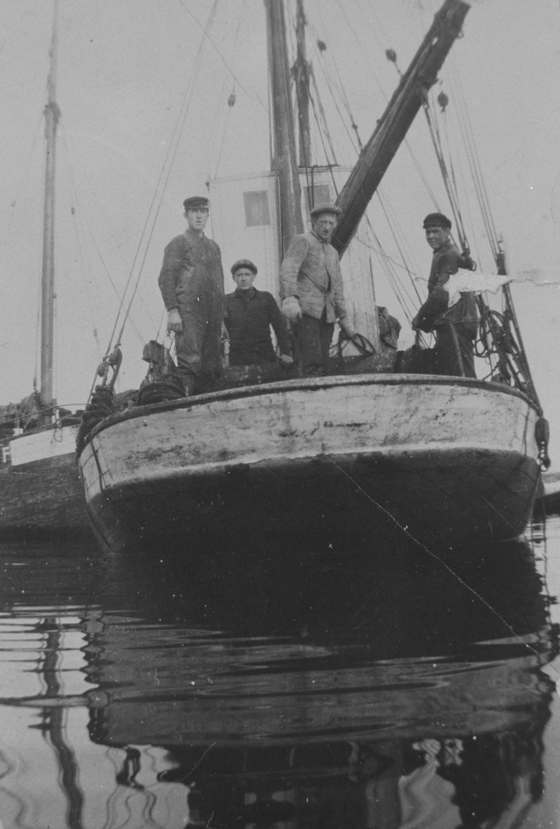 M/K "Sverre" liggende i ro, med mannskap på dekk. Bildet tatt under greiing av storsildgarnslenka i havna på Titran vinteren 1929
