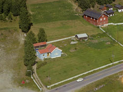 Sør-Fron. Lyseblått privathus med rødt tak. Flere bygninger,