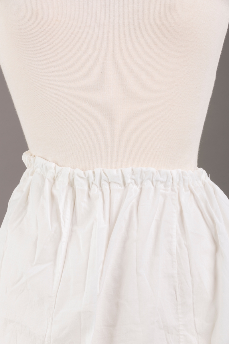 Form: Sydd sammen av seks høyder av ulik bredde og skjæring, blondekant, hullsøm, strikk i livet,