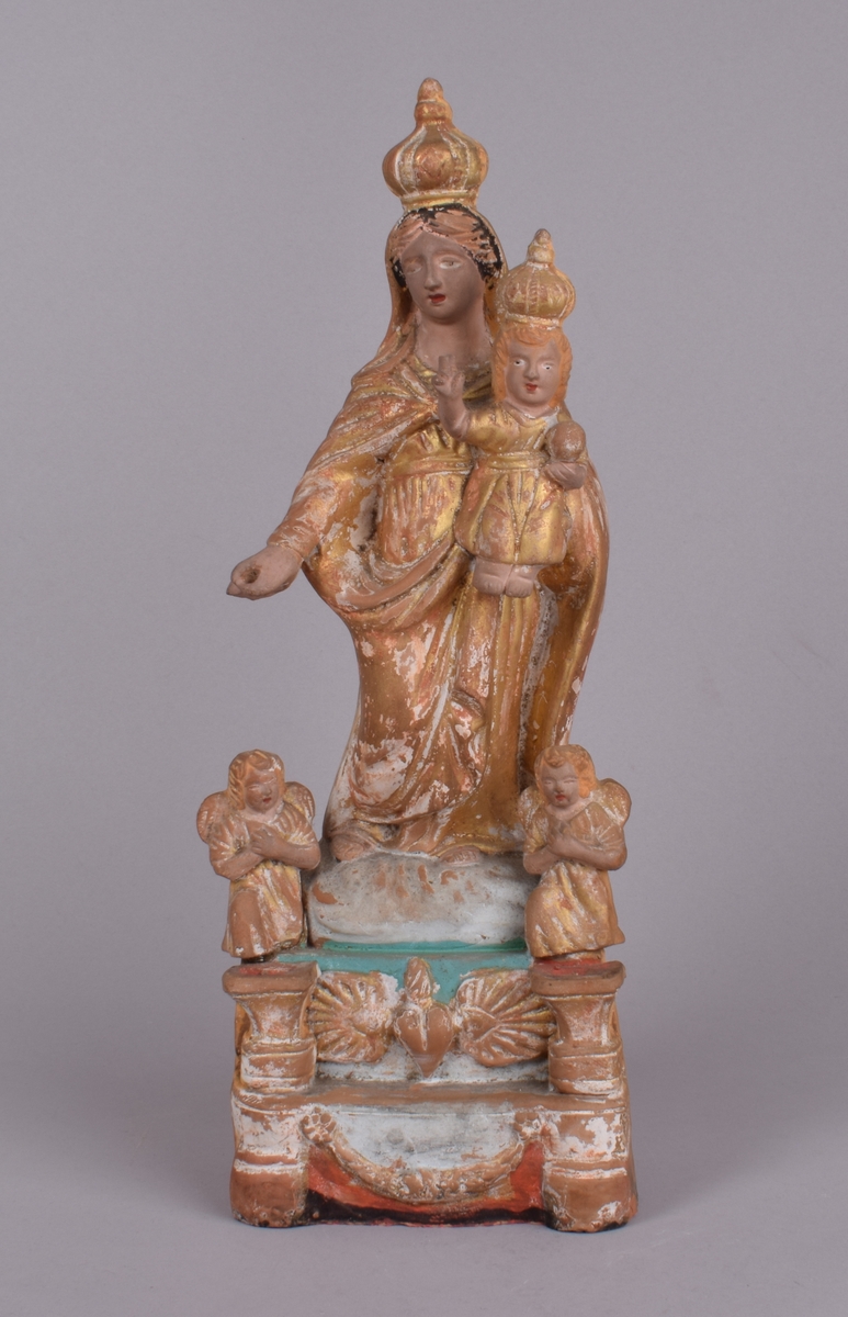 Maria med Jesusbarnet på armen. Begge med kroner. 2 små engler ved Marias føtter.