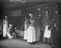 Gruppe jenter med skaut og i kjøkkenet, på kurs ved amtskole