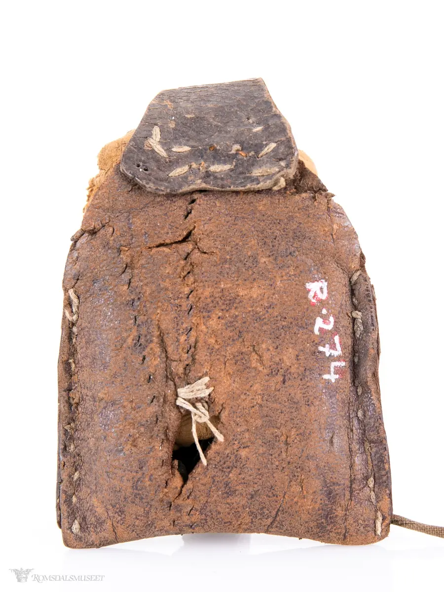 Fyrtøy bestående av en liten lærpose, slagstål, flint og knuskstykker. I posen er det to knuskstykker. Slagstålet har nærmest strykejernsform.