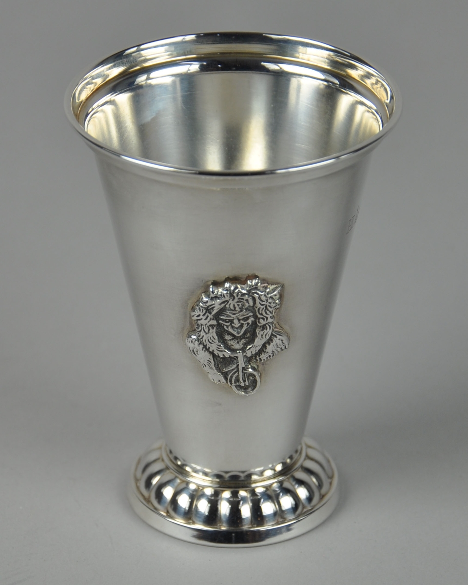 Pokal med dekor på stett og medaljong med bilde av et troll på sykkel