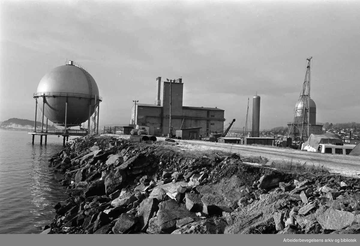 Sjursøya: Gassverket.Til venstre den karakteristiske gassbeholderen. Midt på bildet produksjonsbygningen hvor også administrasjonen har sin plass..Januar 1976