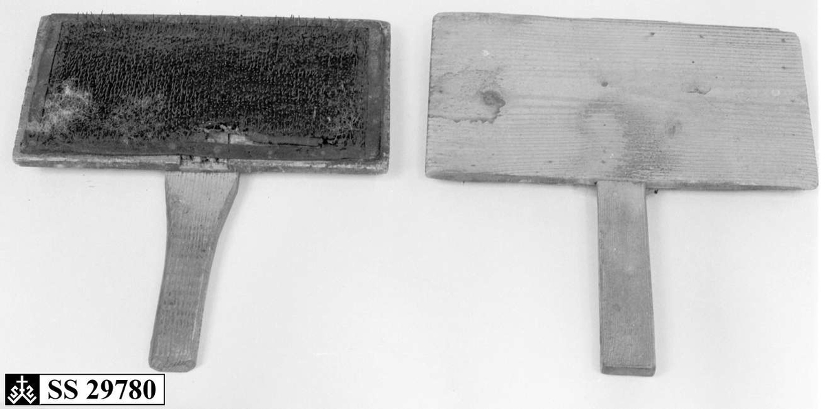 To treplater hvor innsiden av begge platene er dekket av  en skinnduk med tettsittende nåler. Begge treplatene har håndtak.