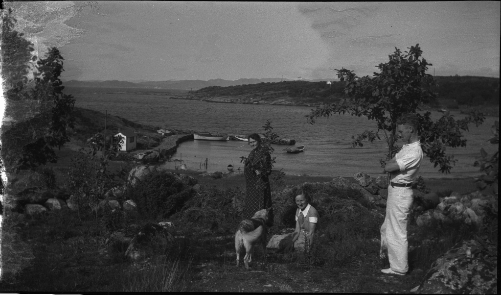 Familien Kamsrud på Tunsøy. Det er bilder av familien ved båten, av Annie Kamsrud og moren, Bertrand Kamsrud (i hvite klær) og to gutter til og hundene deres.