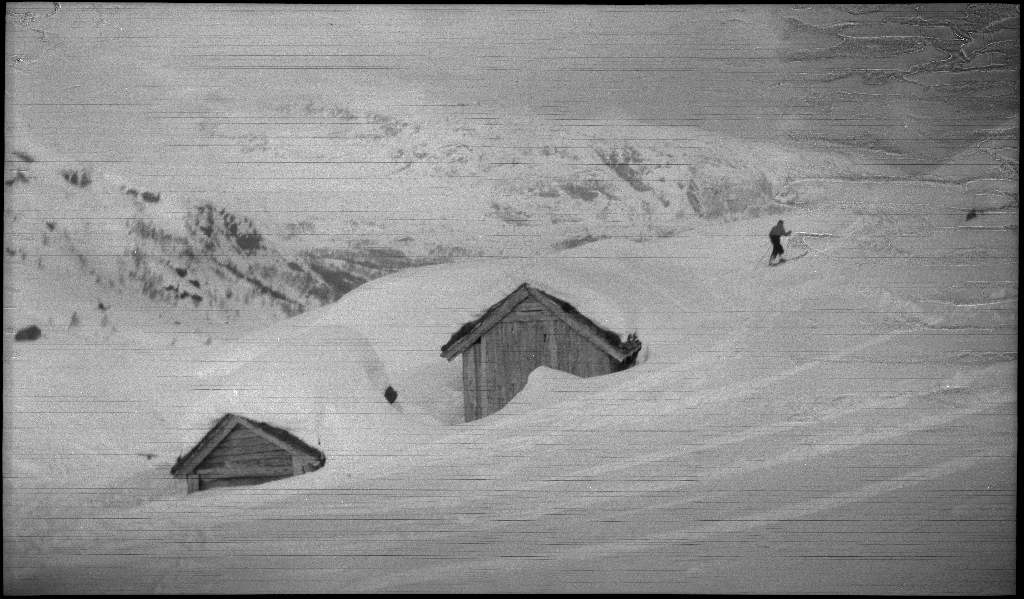 En guttegjeng på skitur i fjellene ovenfor Saudasjøen. Det er bilder av gjengen som går oppover bakkene, og fra en pause ved en gammel hytte.