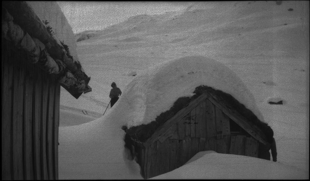 En guttegjeng på skitur i fjellene ovenfor Saudasjøen. Det er bilder av gjengen som går oppover bakkene, og fra en pause ved en gammel hytte.