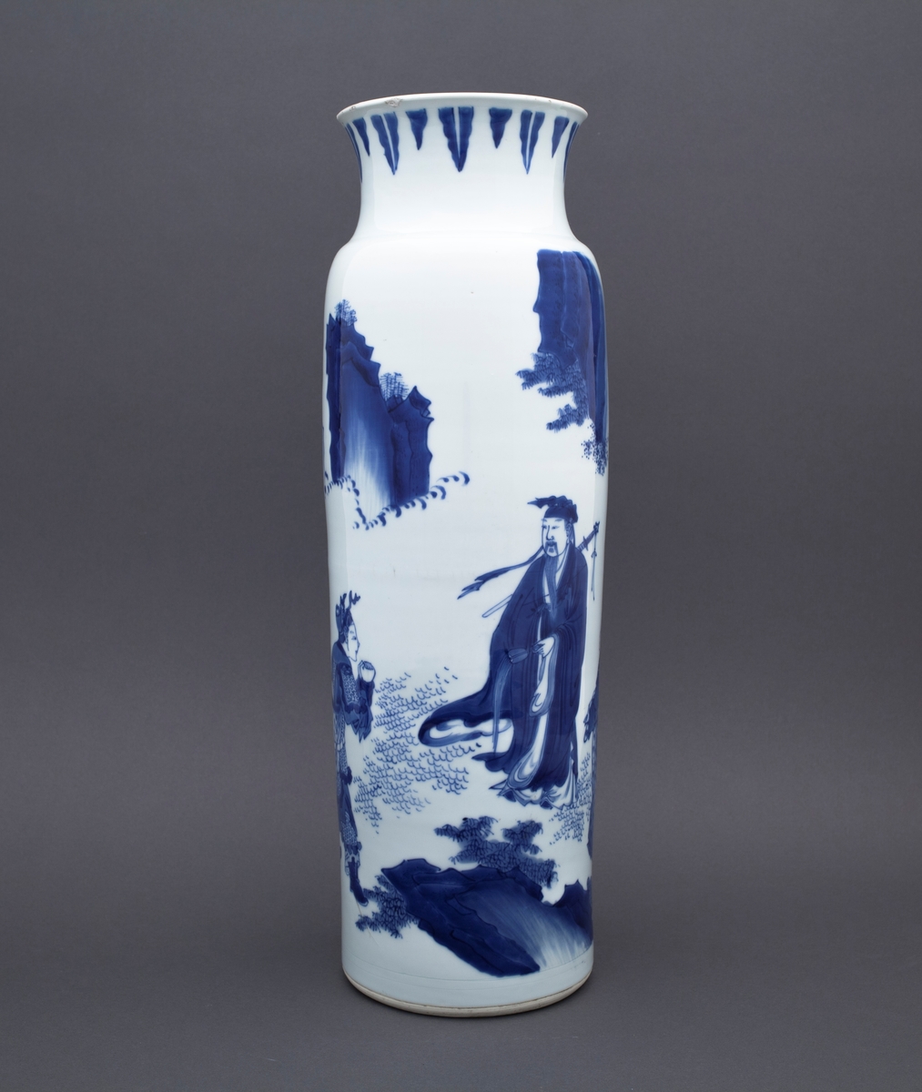 Tre mennesker står foran et stort tre. I bakgrunnen ser vi to fjelltopper. En mann står med foldete hender foran en annen mannsfigur. Han har skjegg, et sverd på ryggen og han holder i en vifte. Ved siden av mannsfiguren med sverd og vifte finner vi en kvinneskikkelse, som også holder i en vifte.