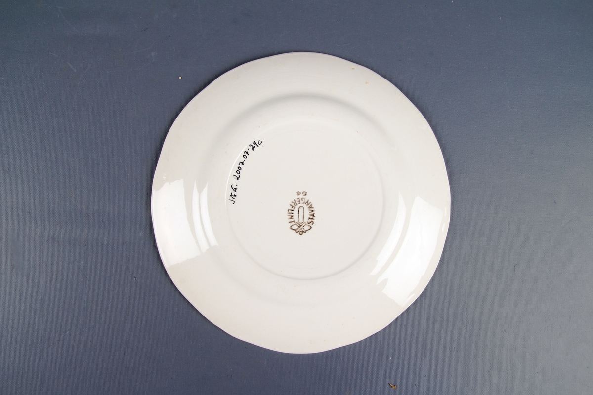 Tallerken med blomsterdekor og gullkant ytterst.