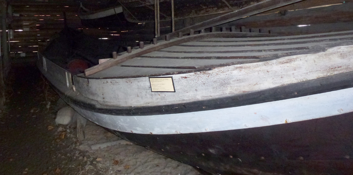 Lofoftbåt av Åfjordtypen, m/mast, rigg, 2 par årer og dregg m/håndlaget tau. Veng i bakskottet. Babord side har påsatt skvettbord fra vengen og litt foran midtskips. Tverr rong i forstavnen. 2 sett tolleganger, - foran vengen og mellom de fremste toflene.