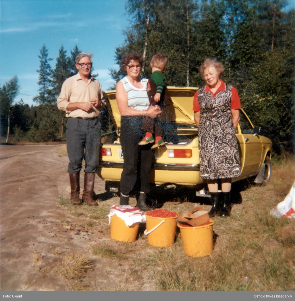 Tyttebærtur i Rømskog 1977. 
Fra venstre trøgstingene Rolf Strengen, Astrid, Laila (2 år) og Thorbjørg Haakaas med bøttene fulle. 
1977 var nok et godt tyttebærår. Bærtur til Rømskog eller Setskog var en del av innhøstingsarbeidet samtidig som det betød en avveksling i hverdagen.