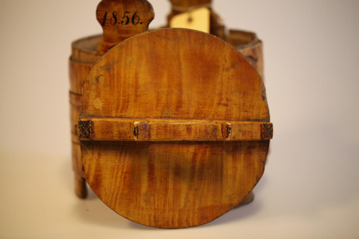 Lagging belagt med tette sveiperinger. Lokk, to ører  og tre bein. Formen er rund, lokk er nedfelt og har avlang hank. Sveip med skjøter (5 stk.) (gjorder). Påmalt gyllengul farge, ådringsmalt.