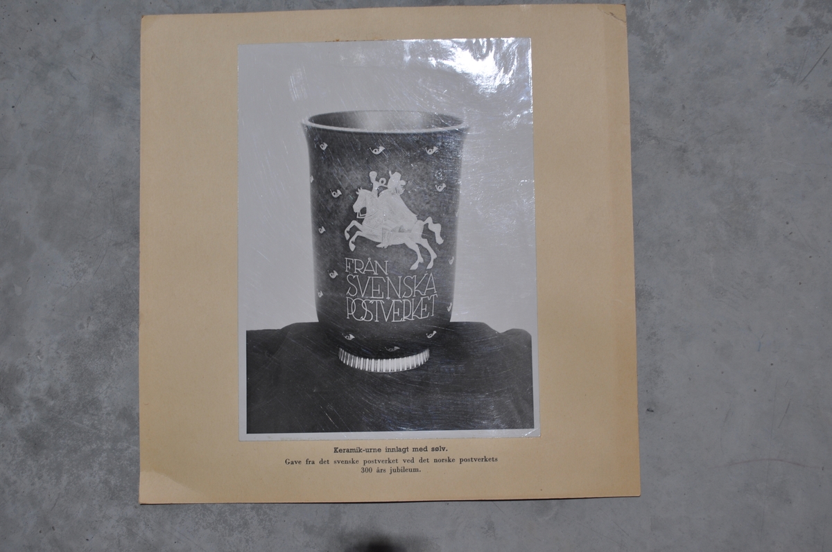 Bilder av framside og bakside av en urne som er gitt av Svenske Postverket i forbindelse med Postens 300 års jubileum.