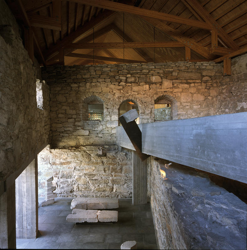 Ramper i rå betong går gjennom den tidligere låven for å løfte publikum opp fra de skjøre middelalderruinene. (Foto/Photo)