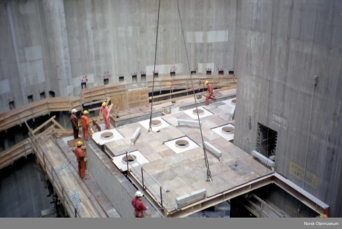 Draugen er under bygging i Jåttåvågen ved Stavanger.
Mye forskjellig utstyr skal monteres under byggeprosessen.
Dekk heises på plass i betongskaftet.