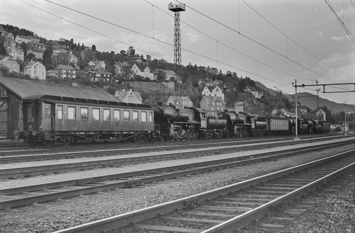 Utrangerte damplokomotiver type 63a på Marienborg. Lokomotivet er underveis til hugging. De tre personvognene benyttes som bremsevogner.