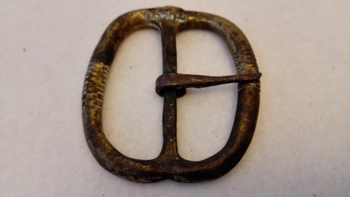 Form: Oval
1 messingspænde.

Stor oval, stöpt messingspænde. Tanden av jern.

Kjöpt av landhandler Theodor Lindström, Lærdal. 