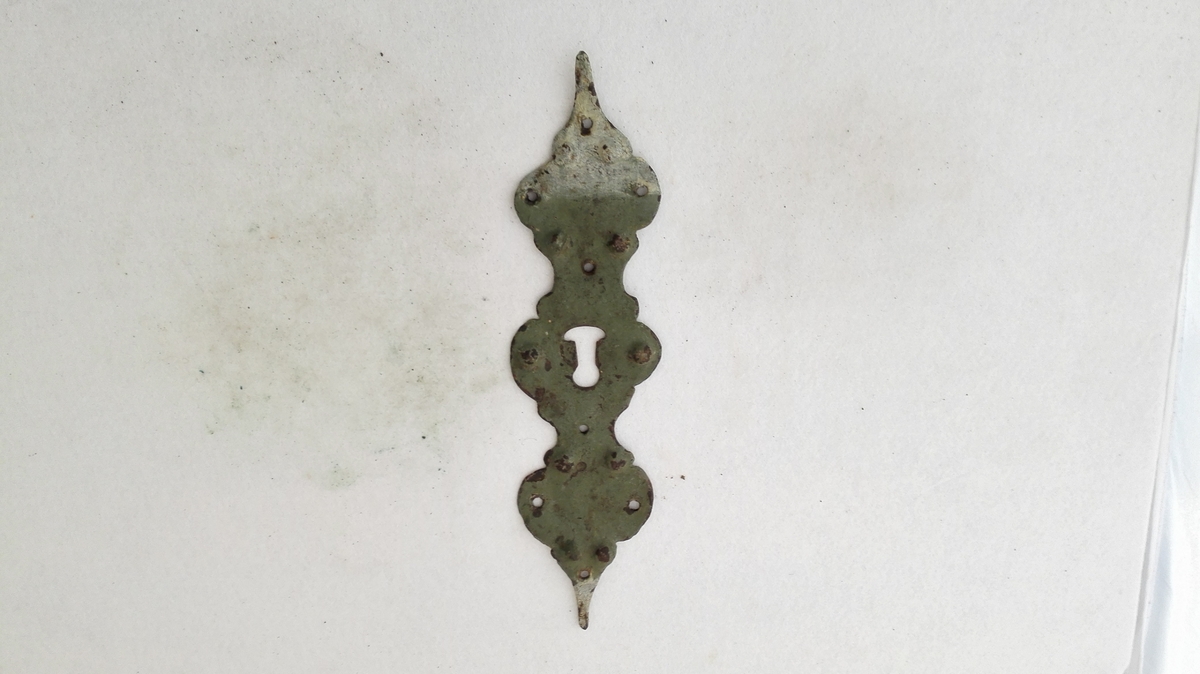1 nökleskildt.

Profilert nökleskildt av jern, 29 cm langt, paa forsiden malt graagrön. Stammer fra et nedrevet hus paa Øvre Amble.

Gave fra G.F. Heiberg, Amble.