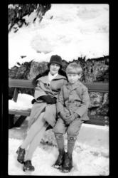 Mor og sønn, Hilda og Rolf Sundt Jr., på en benk i snøen. Fo