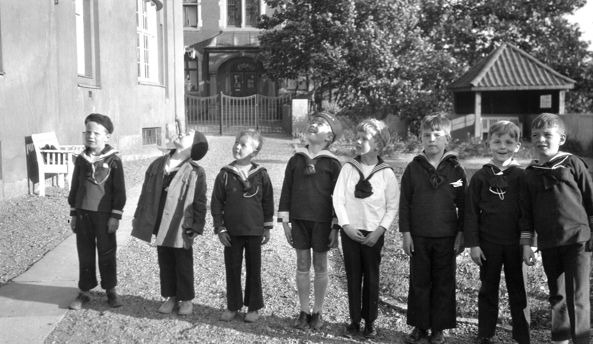 John Lund, Gulbrandsen, Stig Borthen, Tage Munthe-Kaas, Rolf Sundt jr., Herman Kragh, Otto Grieg Tidemand, Anders Østbye står sammen i Heftye terrassen på 7-årsdagen til Rolf Sundt jr. 24. juni 1928.