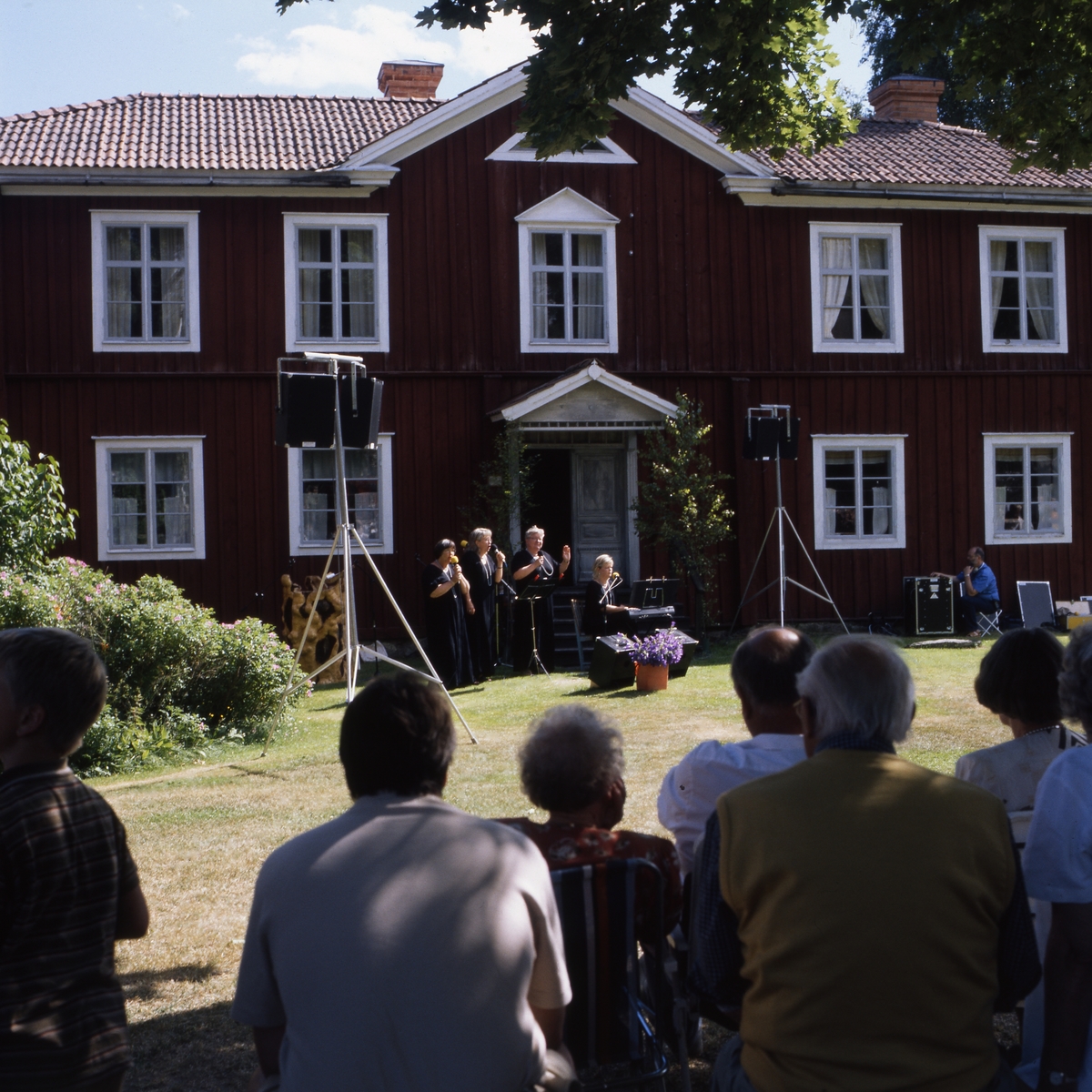 Rengsjöfesten 11 juli 1999. Uppträdande och publik framför Regnells mangårdsbyggnad i Västerby hembygdsby.