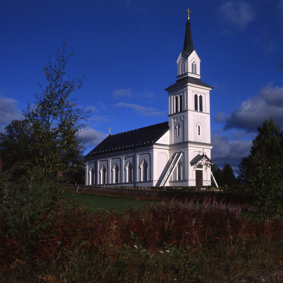 Hamra kyrka från 1872, 1996. Träkyrka som ligger på en höjd med utsikt över skogarna.