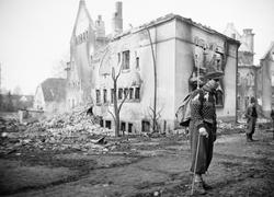 En mann står foran ruiner etter bombingen i Elverum.