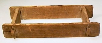 Rektangulär tegelform av trä, sammanfogad med träplugg.