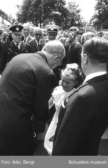 Kungainvigningen 16 juni 1964. 
Fotograf Bengt Adin, Göteborg. Regi Hans Håkansson.
Stenungsunds Centralstation.
Flicka överlämnar blommor till kung Gustaf VI Adolf.